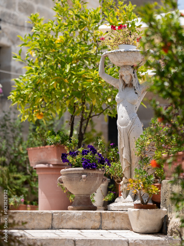 Stone Statue of Woman Carrying a Basket of Flowers in a Mediterranean Garden, Matera