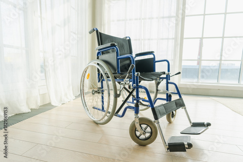 Empty wheelchair waiting for patient services in living room retirement home hospital. Chair for people with disability at home. Handicap accessible symbol. Health care medical lonely elderly sick