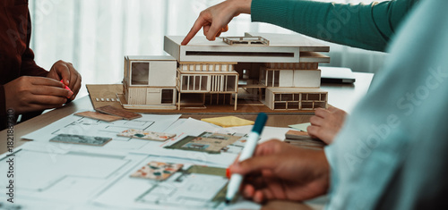 Canvas Print A collaborative design session featuring a scale model of a modern building, architectural blueprints, and engaged professionals brainstorming innovative ideas and solutions