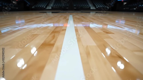 Empty basketball court with polished wooden floor and white lines gleaming under arena lights