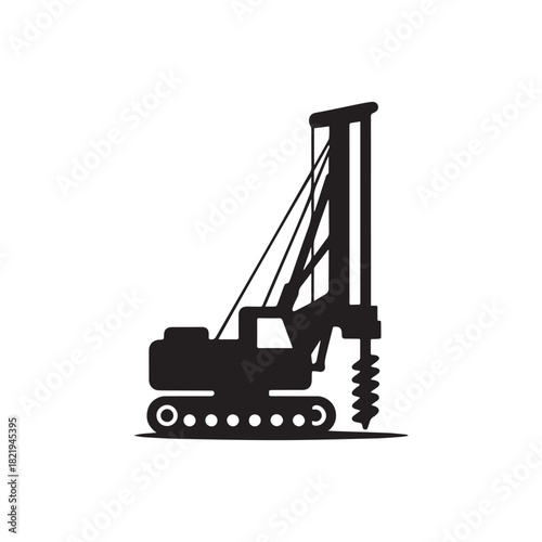 Silhouette of a heavy duty tracked drilling rig with a large auger bit preparing to bore into the ground