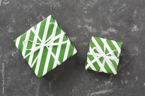 Striped Christmas gift boxes on concrete background, top view