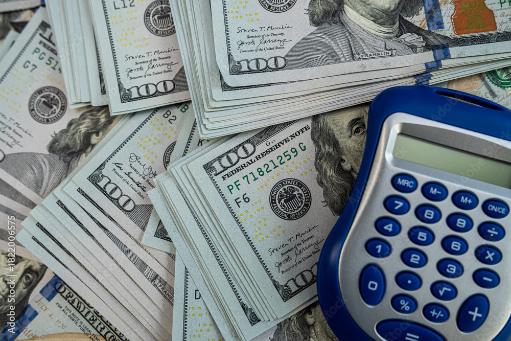 Fototapeta premium Calculator on US dollar banknotes symbolizing finance, accounting, investment and economic analysis