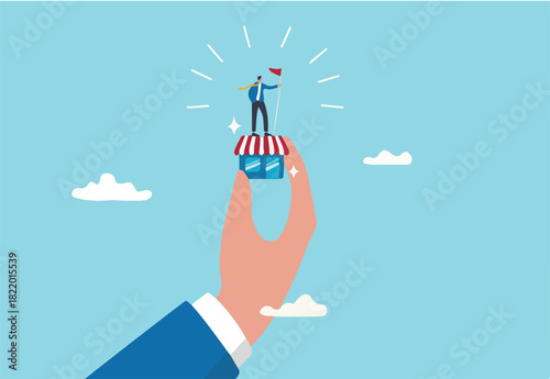 Small business idea, successful entrepreneur with small retail shop or storefront, shop owner or merchandise opportunity concept, success businessman holding winner flag on small store in giant hand