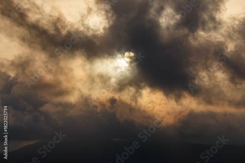 Dramatic Sun Hidden by Dark Clouds