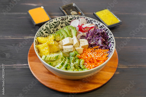 Poke bowl végétarien avec tofu, bol de légumes frais et 3 sauces à côté