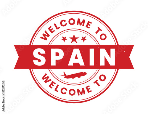 A red circular stamp with the words 'WELCOME TO SPAIN' written on it, featuring an airplane silhouette and stars, symbolizing travel and arrival.