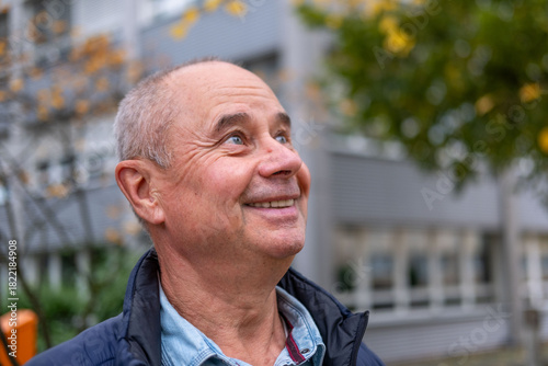 happy positive caucasian mature man 60-65 years old smiling on green natural background, good mood, age-related changes, mental human health
