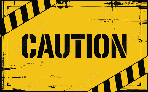 A yellow caution sign with black stripes and the word caution in black stencil letters centered on it