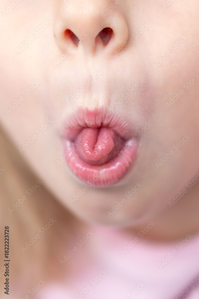 Φωτογραφία Child rolling tongue, Young girl sticking out tongue, playful expression, tongue