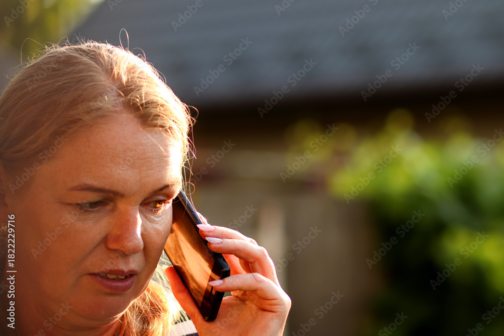 Φωτογραφία closeup shot of a woman engaged in a serious phone talk outside