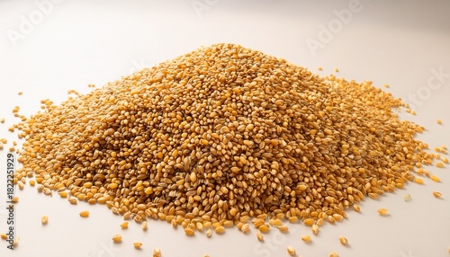 pile of golden grain seeds on a light background copy space