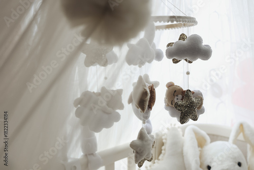 Close up of a felt nursery mobile with clouds, stars and animals,highlighting handmade quality.Suited for baby product brands, Etsy sellers, and nursery decor marketing. ideal for ads,packaging, blogs
