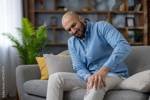 Man suffering from knee pain massaging his injured leg