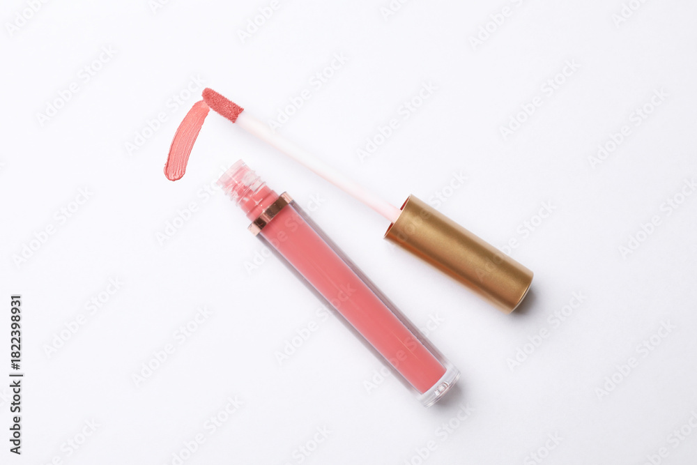 Fototapeta premium Beautiful lip gloss with applicator on white background, top view