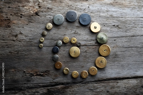 Vintage Brass Button Collection Arranged in a Spiral Pattern for Antique Crafts and Historical Sewing