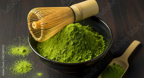 Vibrant Green Matcha Tea Powder in a Black Bowl with Traditional Bamboo Whisk (Chasen), on a Dark Wooden Background.