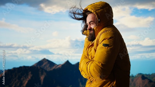 Fotografía Male nature lover struggling with the cold windy weather on the mountain top, climbing the rocky hills and feeling cold