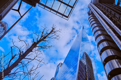 Wide-angle view of skyscrapers in the City of London against a blue sky with light cloud.