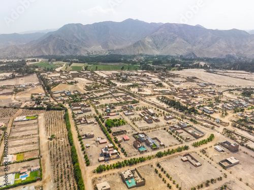 Aerial view of a sprawling residential development in the Cieneguilla valley near Lima Peru featuring houses and plots against a backdrop of arid mountains.