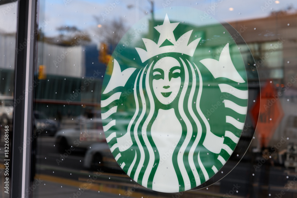 Fototapeta premium Starbucks Coffee Mermaid logo sign inside a display window, Toronto