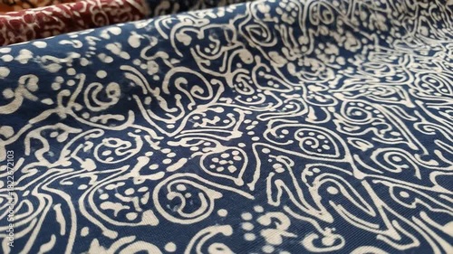 Closeup of blue fabric with white swirling and dotted designs
