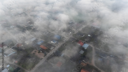 Fototapeta Naklejka Na Ścianę i Meble -  Aerial view of small village in Pa Daet district in Chiang Rai province of Thailand covered with fog in winter season. 