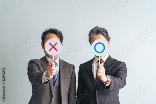 マルバツサインを見せるミドルエイジ男性ビジネスパーソンのグループ