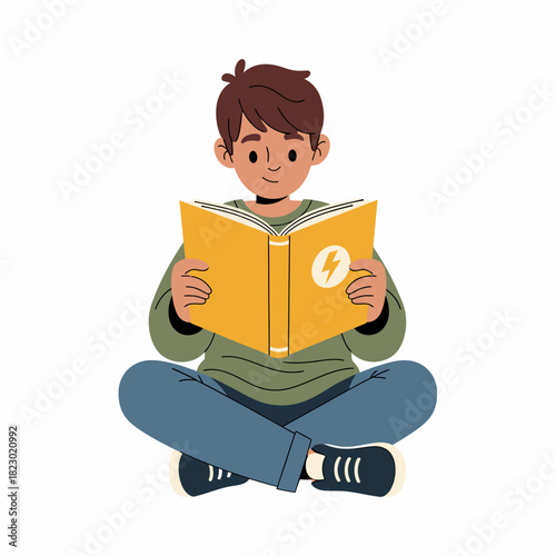 Young boy engrossed in reading a book while sitting cross legged.
