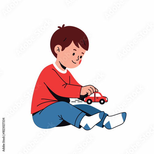 Young boy playing with a red toy car while sitting down.