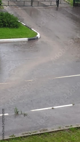 Heavy summer downpour flooding an asphalt road