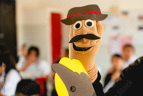 Hand puppet character teaching children in classroom