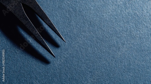 A detailed macro shot showcasing the pointed tines of a dark fork creating dramatic shadows on a shimmering blue glitter surface.