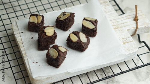 Selective focus pieces almond brownies on cooling rack, white background