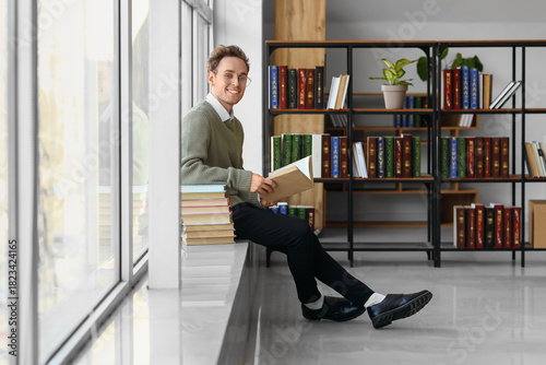 Young man reading book in l...