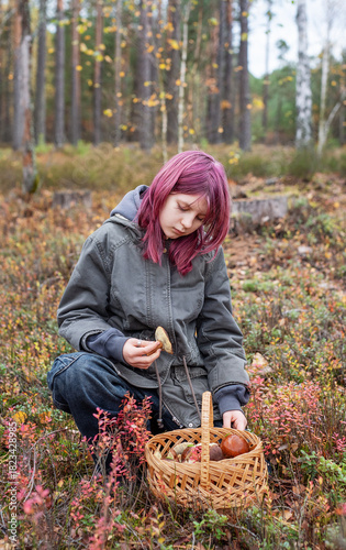Girl foraging wild mushrooms in autumn forest