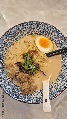 Asian noodle soup, ramen with beef, vegetables and egg in bowl