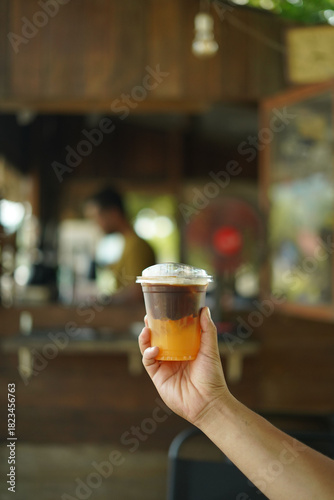 holding a cup of black coffee orange
