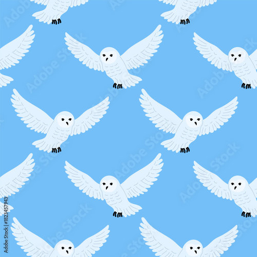 Snowy owls flying in a bright sky pattern during a sunny day, showcasing their graceful wings and distinct features