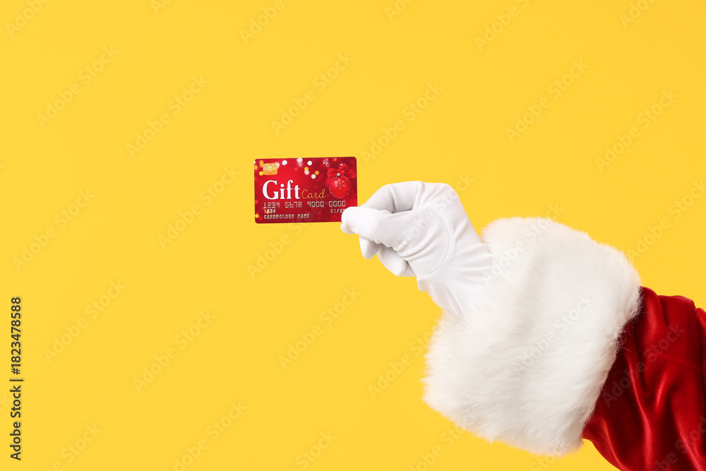 Naklejka premium Santa Claus holding gift card on color background, closeup