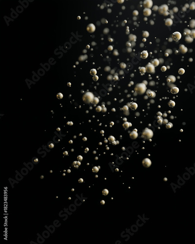 Golden bubbles float in random scatter against black background, creating sense of movement and elegance, with dreamy and abstract visual effect