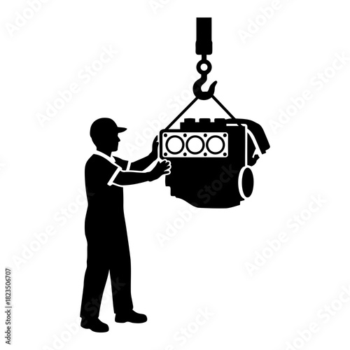 Mechanic lifting engine block with crane for automotive repair or maintenance job