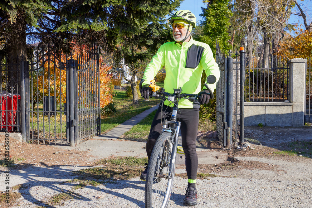 Obraz premium Old man exercising by riding a bicycle on a beautiful autumn day