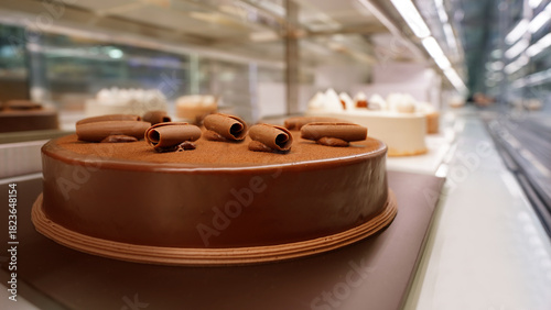 Rich chocolate cake displayed in bakery refrigerated showcase