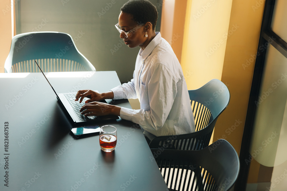 Naklejka premium Professional individual working with a laptop in a modern office setting