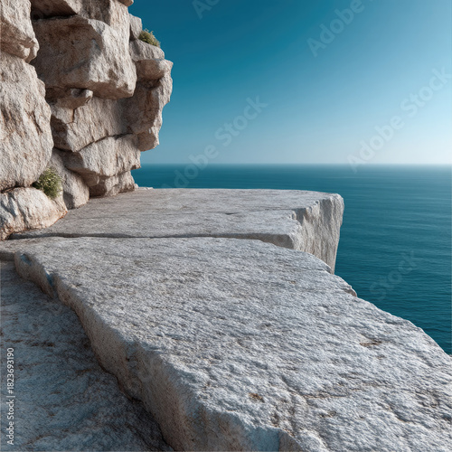 White stone cliff edge overlooking calm blue sea, clear sky, natural landscape, peaceful and serene atmosphere