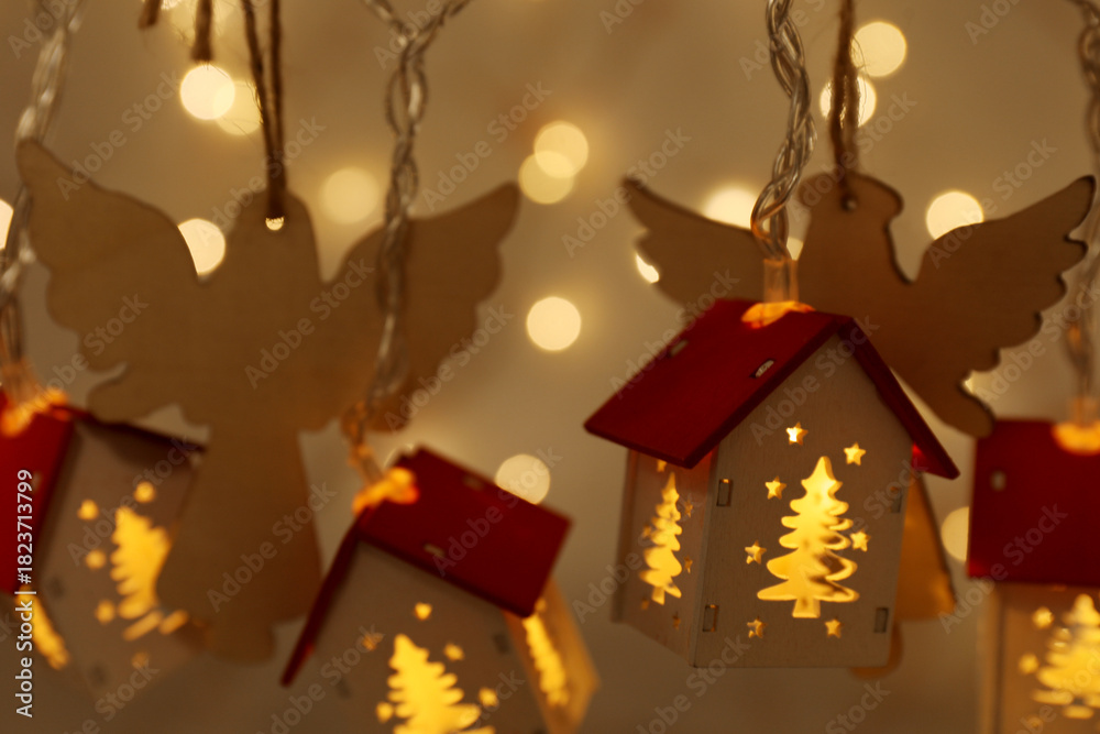 Fototapeta premium Different Christmas decor hanging against golden background with blurred lights, closeup. New Year greeting card