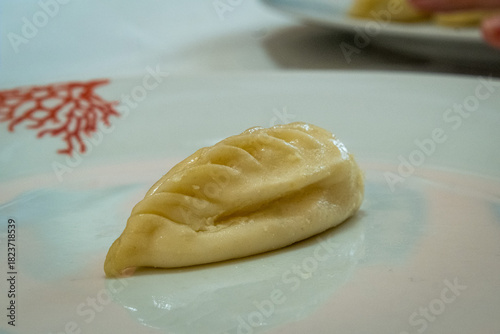 Homemade traditional Sardinian pasta called Culurgiones on a porcelain plate
