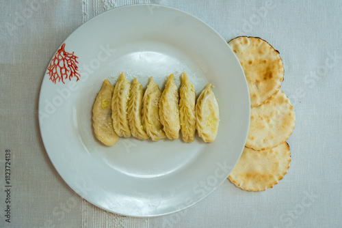 Homemade traditional Sardinian pasta called Culurgiones on a porcelain plate