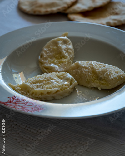 Homemade traditional Sardinian pasta called Culurgiones on a porcelain plate